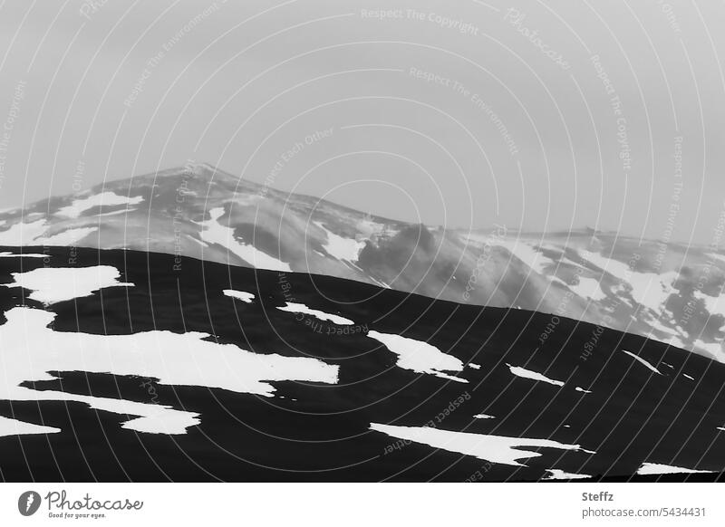 Berge und Hügel bei bewölktem Himmel auf Island Nordisland Felsen Schneereste nordisch hügelig Islandreise Stille Schwermut sagenhaft schwermütig Geheimnis