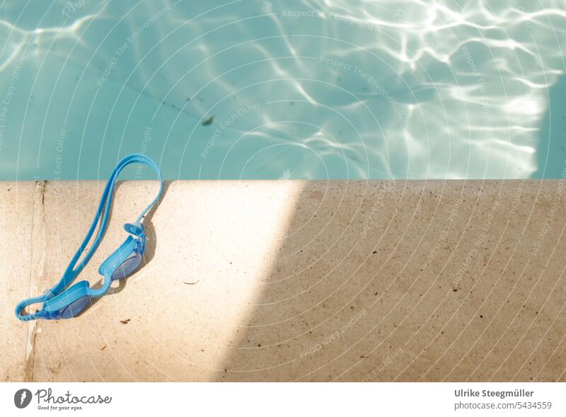 Eine blaue Taucherbrille liegt am Schwimmbeckenrand Sommerurlaub Sonne Italien Pool schwimmen tauchen Licht Schatten Abendsonne Wasser