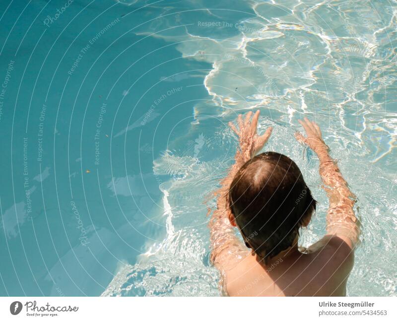Ein Kind schwimmt im Pool Sommer Mut der erste Schritt Schwimmen lernen ins Ungewisse schwimmen sich etwas trauen Urlaub mit Kindern tauchen blau Wasser Italien