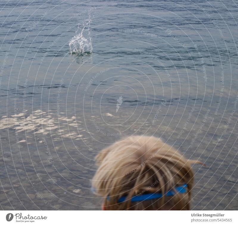 Kind wirft einen Stein in den See Urlaub mit Kindern Lago Maggiore Italien Sommerurlaub Schwimmen Tauchen Taucherbrille Steinwurf Wasserspritzen klares Wasser