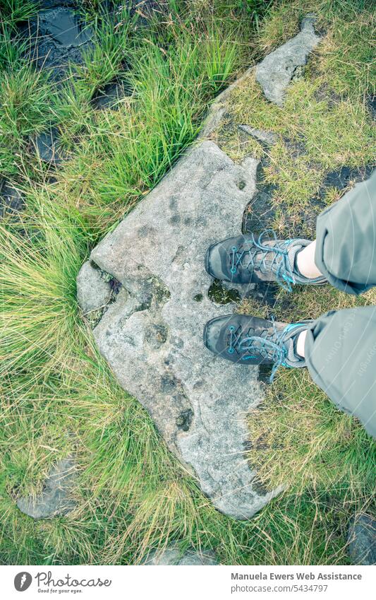 Eine Person mit nassen Schuhen steht auf einem Stein. Der Blick der Kamera ist aus der Ich-Perspektive nach unten gerichtet. nasse füße durchweicht wandern