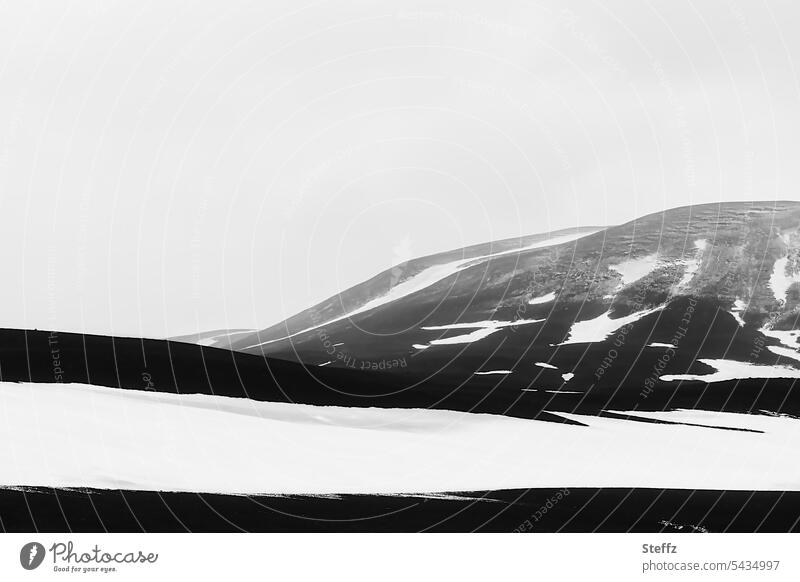 Schneeschmelze auf der Bergseite auf Island Nordisland isländisch abstrakt Schneeformen Abstraktion abstrakte Formen Islandreise Felsen Himmelgrau Islandwetter