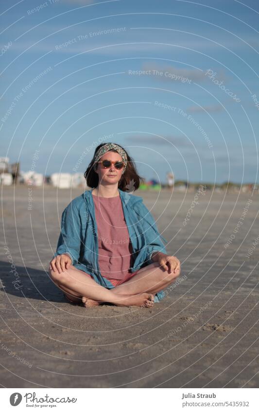 Meditation Meer Strand Sand sitzen Schneidersitz Yoga meditieren Ruhe Auszeit Erholung Frau Gesundheit Sonnenbrille Wind Haarband Sommer