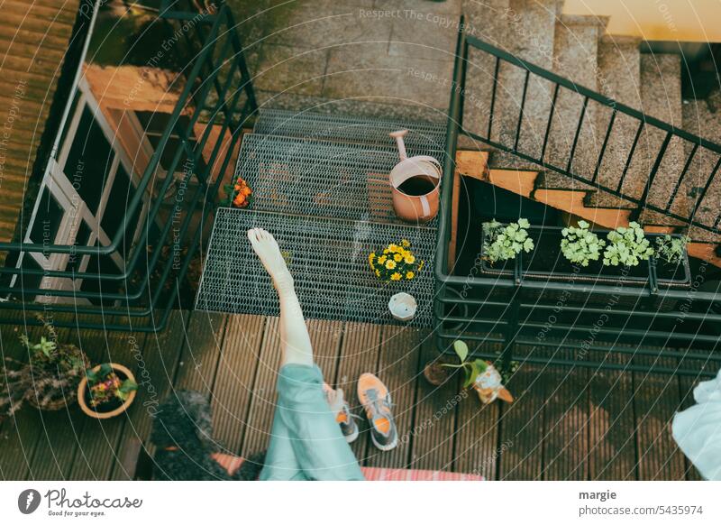 Entspannung in einem Haus- Innenhof Balkon Treppe Treppenhaus Füße hoch Mädchen Hund Blumentopf Gießkanne Schuhe orange Außenaufnahme Blumenkasten Holzfußboden