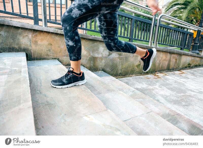 Weibliche Beine in Leggings beim Training auf einer Treppe in der Stadt unkenntlich Frau Herz Läufer Treppenhaus Schritt nach oben rennen laufen Geschwindigkeit