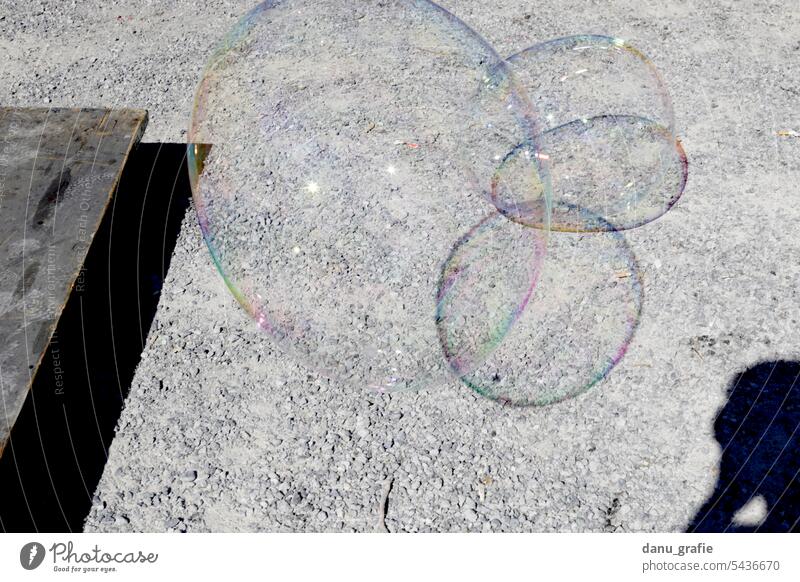 Seifenblasen schweben vor Kiesboden schwebende Seifenblasen bubbles durchsichtig leicht Schwerelosigkeit mehrfarbig Schweben fliegen Leichtigkeit Freude