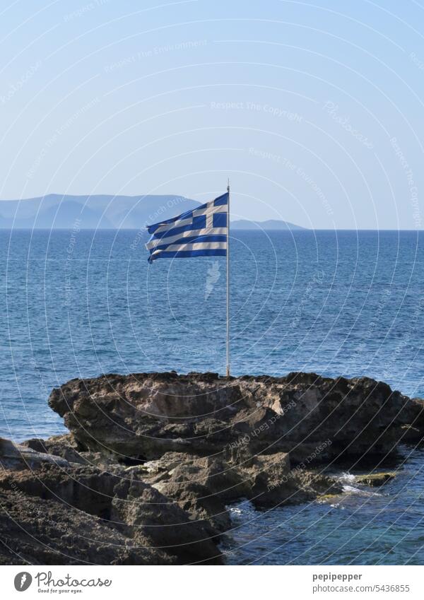 Griechische Flagge auf einem Fels vor der Küste griechische Flagge Nationalflagge Fahne Patriotismus Wind flattern Griechenland Griechische Inseln Fahnenmast
