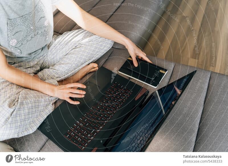 Eine Frau in Hauskleidung benutzt einen Laptop Netzwerk Internet Anschluss Heimarbeitsplatz Notebook Telefon häusliches Leben Computer Menschen Job Mobile