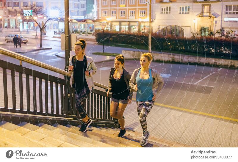 Freundinnen trainieren Treppensteigen in der Stadt bei Nacht Frau Team Menschengruppe Läufer Frauen Training Treppenhaus Schritt nach oben rennen Großstadt Bein