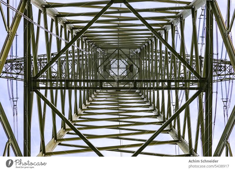 Symmetrische bottom-up Ansicht vom einem Hochspannungsmast mit Linien von Stahlträgern Strommast Froschperspektive Drähte Pylon Stahlkonstruktion Stromnetz Zoom