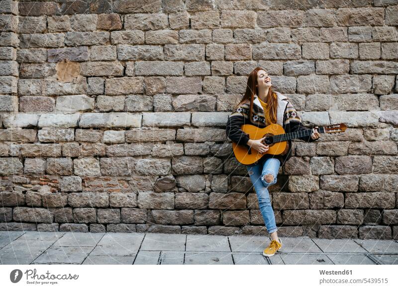 Rothaarige Frau spielt die Gitarre in der Stadt Musik weiblich Frauen Musikerin Musikerinnen rothaarig rote Haare rothaarige rotes Haar rothaariger rothaariges