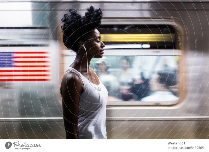 USA, New York City, Manhattan, Frau mit Kopfhörern auf dem Bahnsteig einer U-Bahn-Station weiblich Frauen Erwachsener erwachsen Mensch Menschen Leute People
