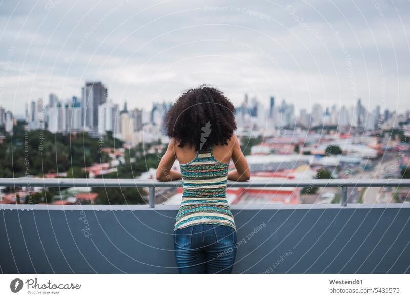 Panama, Panama City, Rückenansicht einer jungen Frau, die auf einem Balkon steht und die Aussicht betrachtet schauen sehend Balkone weiblich Frauen stehen
