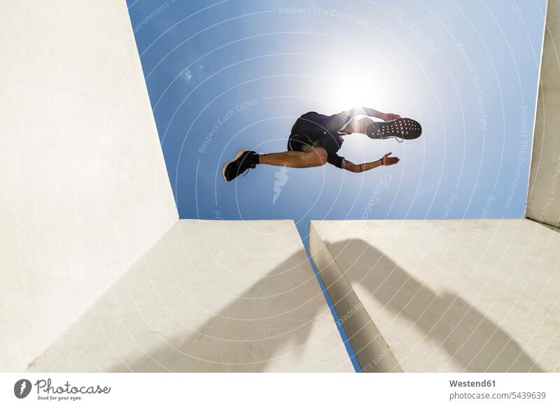 Mann springt in der Stadt während einer Parkour-Session Freerunning Luftsprung Luftsprünge einen Luftsprung machen Luftspruenge springen hüpfen Sprung Spruenge