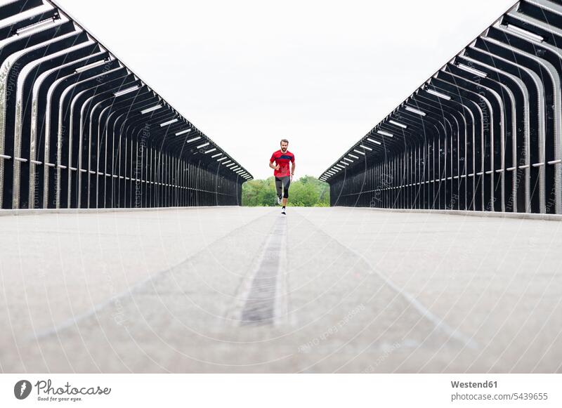 Mann rennt auf einer Brücke Männer männlich Bruecken Brücken laufen rennen Erwachsener erwachsen Mensch Menschen Leute People Personen Deutschland Himmel