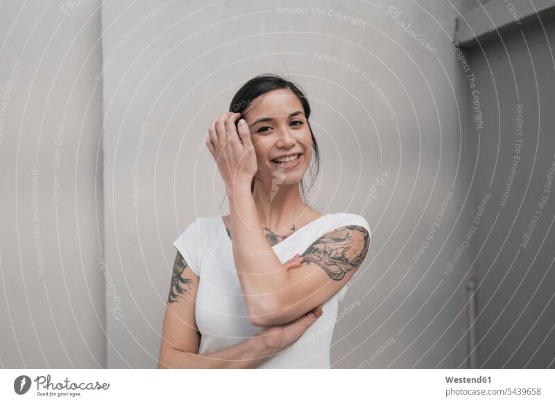 Porträt einer jungen Frau mit Tätowierungen, lächelnd weiblich Frauen fröhlich Fröhlichkeit Frohsinn Heiterkeit Portrait Porträts Portraits Tattoo Tatoos