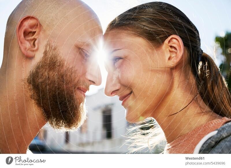 Junges verliebtes Paar im Gegenlicht von Angesicht zu Angesicht Pärchen Paare Partnerschaft glücklich Glück glücklich sein glücklichsein Mensch Menschen Leute