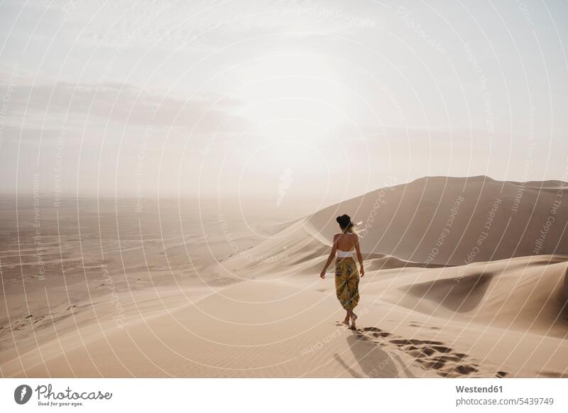Namibia, Namib, Rückenansicht einer Frau, die barfuß auf einer Wüstendüne läuft Wüstendünen Wuestenduene Wuestenduenen weiblich Frauen Düne Duenen Dünen