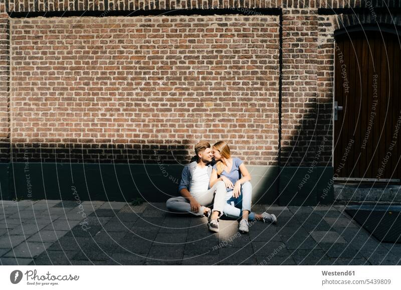 Niederlande, Maastricht, junges Paar, das eine Pause in der Stadt auf dem Bürgersteig sitzt staedtisch städtisch Gehsteig Gehwege Gehsteige Bürgersteige