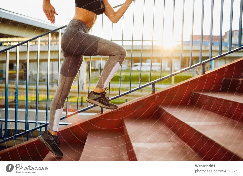Frau rennt auf Treppen in der Stadt Joggen Jogging Bein Beine laufen rennen trainieren Treppenaufgang weiblich Frauen Fitness fit Gesundheit gesund Sport Mensch