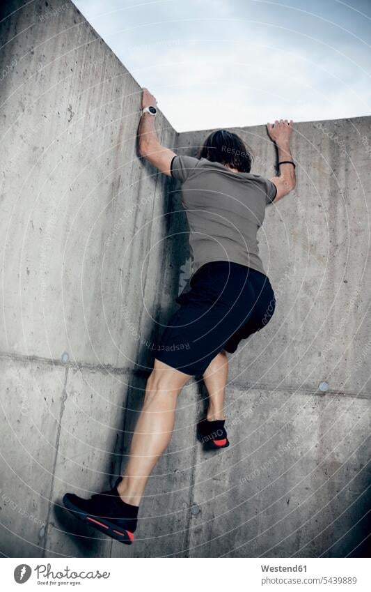 Sportler klettert Betonwand im Freien hoch Mann Männer männlich klettern steigen Betonwände Betonwaende Erwachsener erwachsen Mensch Menschen Leute People