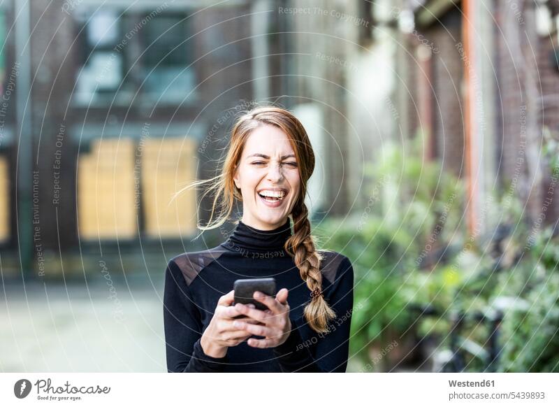 Porträt einer lachenden Frau mit Smartphone weiblich Frauen iPhone Smartphones Erwachsener erwachsen Mensch Menschen Leute People Personen positiv Emotion