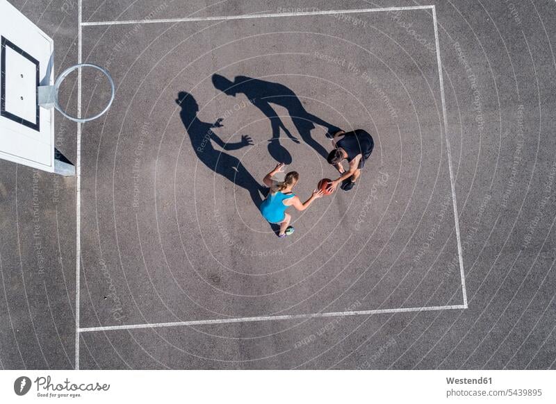Junger Mann und Frau spielen Basketball, Luftaufnahme Sport Basketballkorb Basketballkoerbe Basketballkörbe Linie Linien Gegner Abwehr abwehren sportlich