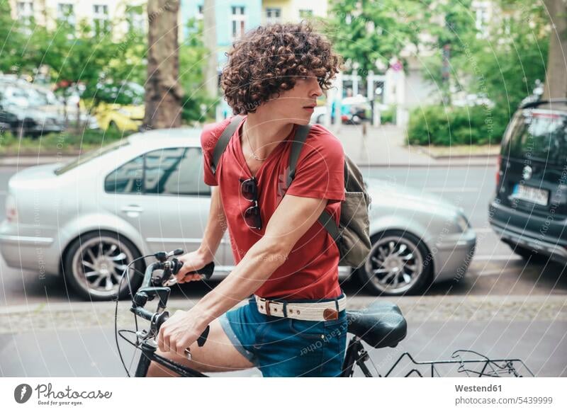 Junger Mann fährt Fahrrad auf Bürgersteig und kehrt um fahren fahrend fahrender fahrendes Gehsteig Gehwege Gehsteige Bürgersteige Straßenpflaster Trottoir Bikes