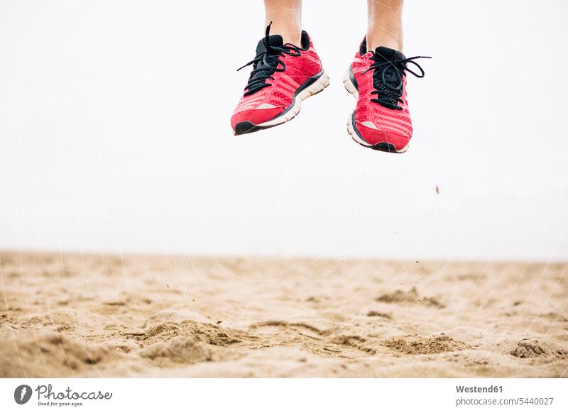 Beine eines Athleten, der aus der Luft im Sand springt trainieren Textfreiraum Fitness fit Gesundheit gesund Aktivität Aktivitaet aktiv Vitalität Elan Schwung