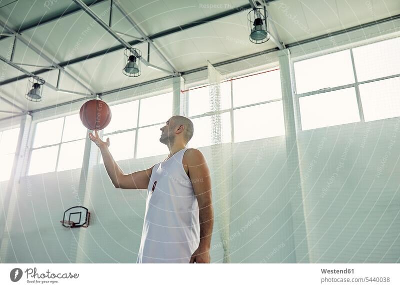 Mann spielt mit Basketball, in der Halle balancieren Balance drehen Hand Hände Freizeitsport Basketballspieler Basketballer Sport ausgeglichen Ausgeglichenheit