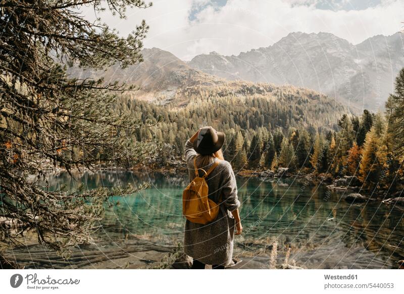 Schweiz, Engadin, Frau auf einer Wanderung stehend am Seeufer in Berglandschaft Berge weiblich Frauen Gebirge Gebirgslandschaft Gebirgskette Gebirgszug steht