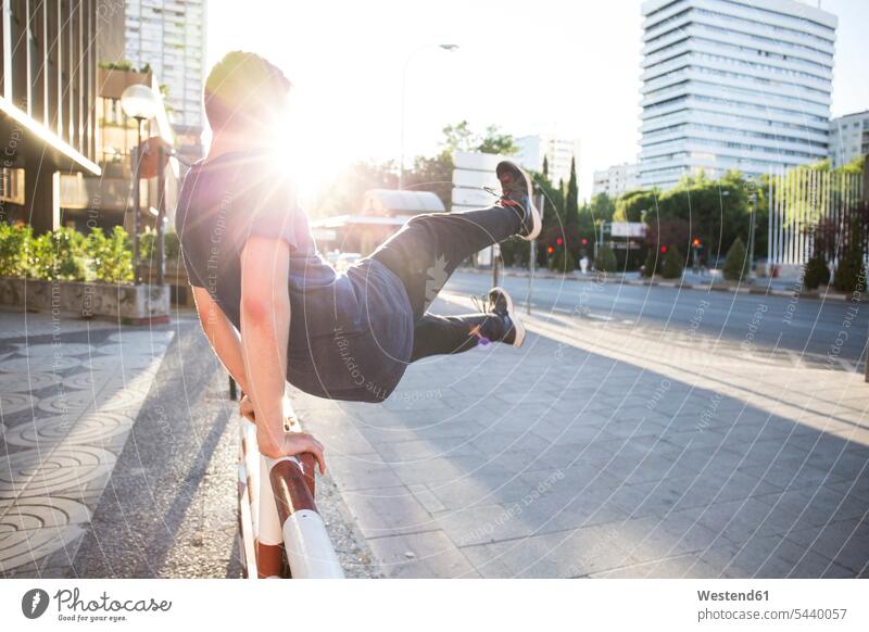 Spanien, Madrid, Mann springt während einer Parkour-Sitzung über einen Zaun in der Stadt aktiv Freerunning springen hüpfen Männer männlich Sport Freizeit Muße