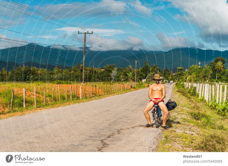 Laos, Vang Vieng, junger Mann mit Fahrrad auf der Strasse Bikes Fahrräder Räder Rad Straße Strassen Straßen Männer männlich Raeder Verkehrswesen Transportwesen