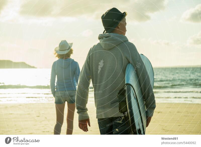 Teenager-Paar, das in der Abenddämmerung am Strand spazieren geht Finistere Blick in die Ferne Freunde Erwachsen werden Gemeinsamkeit zusammen gemeinsam Jugend