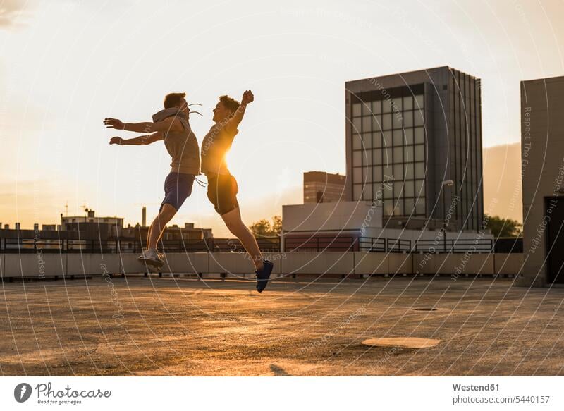 Freunde springen bei Sonnenuntergang vor Freude hüpfen fit Basketball Basketbaelle Basketbälle glücklich Glück glücklich sein glücklichsein jung spielen Spaß
