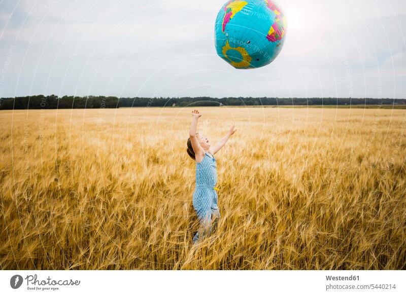 Mädchen steht im Getreidefeld und spielt mit dem Globus Weltkugel Erdkugel Globen Kornfeld Getreidefelder Kornfelder Feld Felder glücklich Glück glücklich sein
