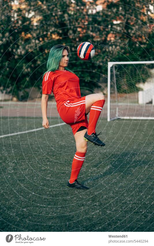 Junge Frau spielt Fußball auf Fußballplatz balancieren den Ball spielen weiblich Frauen Fussball Fussballplatz Fußballplätze Fussballplaetze Bälle Balance