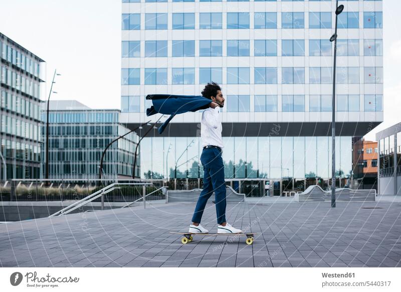 Spanien, Barcelona, junger Geschäftsmann fährt Skateboard in der Stadt Mann Männer männlich staedtisch städtisch fahren Businessmann Businessmänner