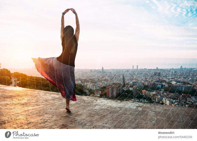 Spanien, Barcelona, Frau tanzt am Aussichtspunkt über der Stadt weiblich Frauen morgens Morgen früh Frühe Ausblick Ansicht Überblick Sonnenaufgang