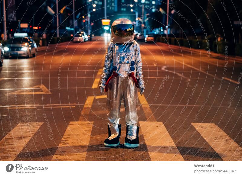 Spaceman stehend auf einer Straße in der Stadt bei Nacht Astronaut Astronauten nachts staedtisch städtisch steht Strassen Straßen Raumfahrer Weltraumfahrer