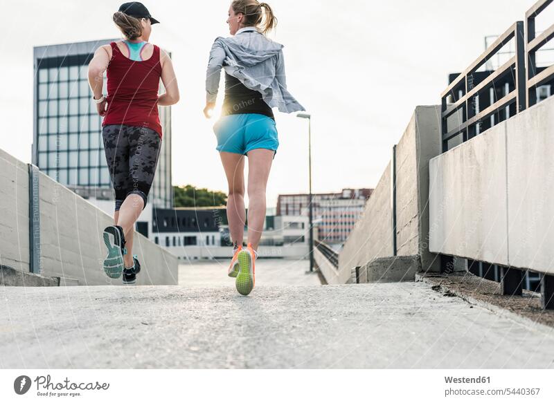 Zwei Frauen laufen in der Stadt Joggen Jogging rennen Freundinnen weiblich Fitness fit Gesundheit gesund Sport Freunde Freundschaft Kameradschaft Erwachsener