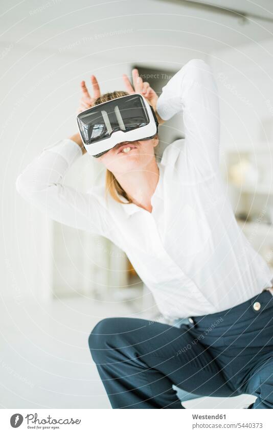 Geschäftsfrau mit VR-Brille, die vorgibt, ein Hase zu sein Brillen Virtuelle Realität Virtuelle Realitaet Kaninchen Geschäftsfrauen Businesswomen Businessfrauen