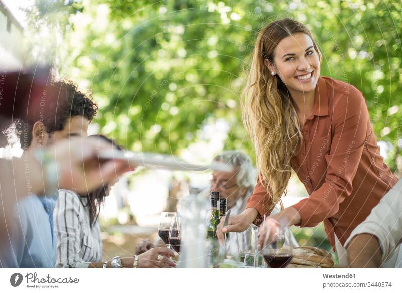 Lächelnde Frau beim Familienessen im Garten auftischen Gruppe Gruppe von Menschen Menschengruppe Freunde lächeln Rotwein Rotweine feiern Wein Weine Leute People