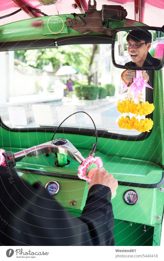 Thailand, Bangkok, Fahrer amüsiert sich in seinem Tuk-Tuk-Taxi grün Service Dienstleistung fröhlich Fröhlichkeit Frohsinn Heiterkeit lachen Lebensfreude