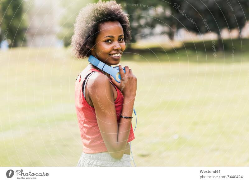 Porträt einer lächelnden, sportlichen jungen Frau im Park weiblich Frauen trainieren Joggen Jogging Parkanlagen Parks Erwachsener erwachsen Mensch Menschen