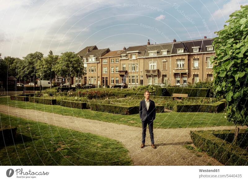 Niederlande, Venlo, Geschäftsmann im Stadtpark stehend steht staedtisch städtisch Park Parkanlagen Parks Businessmann Businessmänner Geschäftsmänner