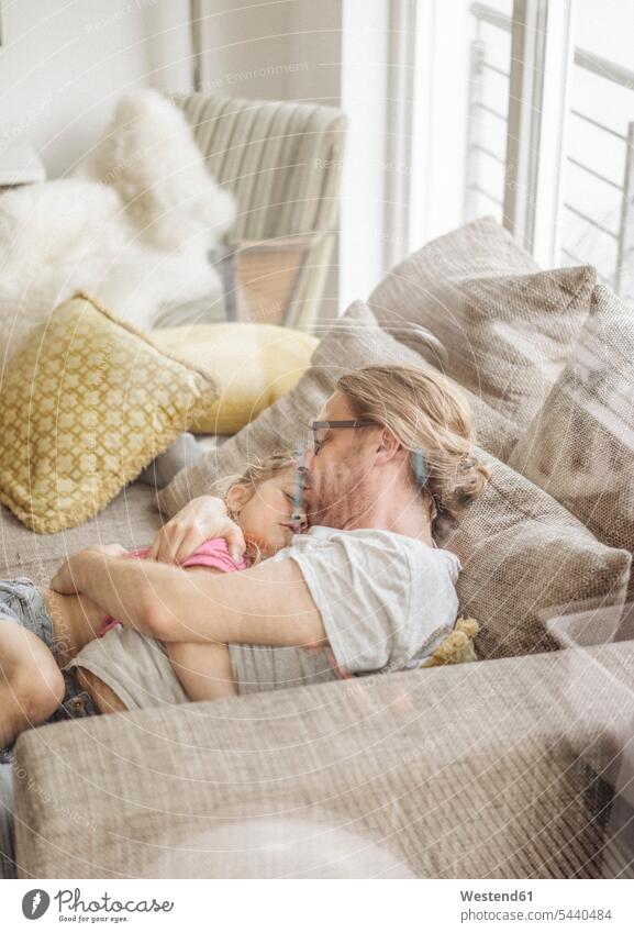 Vater entspannt sich mit der Tochter auf dem Sofa Couches Liege Sofas liegen liegend liegt glücklich Glück glücklich sein glücklichsein Papas Väter Vati Vatis