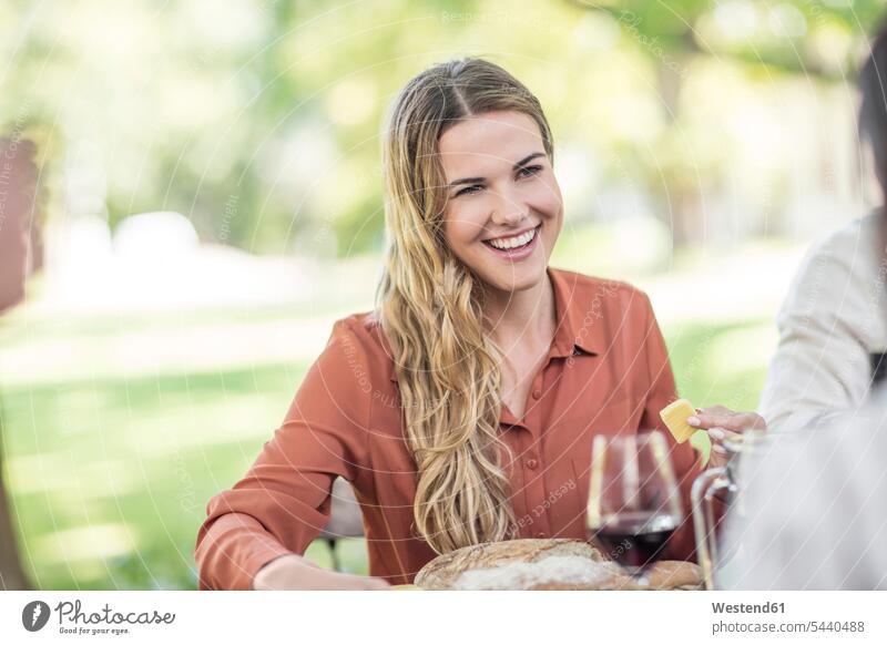 Lächelnde Frau beim Familienessen im Garten feiern Wein Weine Rotwein Rotweine lächeln Gruppe Gruppe von Menschen Menschengruppe Freunde Alkohol
