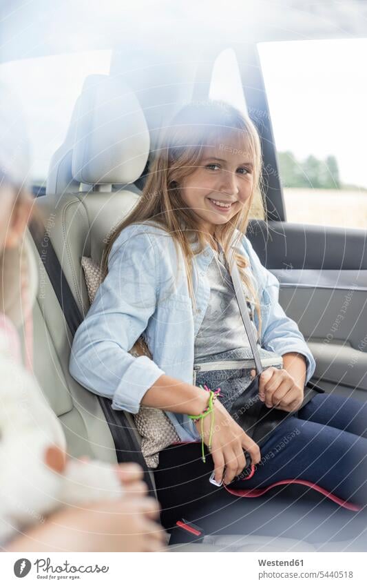 Im Auto sitzendes Mädchen, Sicherheitsgurt anlegen sitzt Wagen PKWs Automobil Autos lächeln Urlaub Ferien Autoreise anschnallen Sicherheitsgurte Anschnallgurt