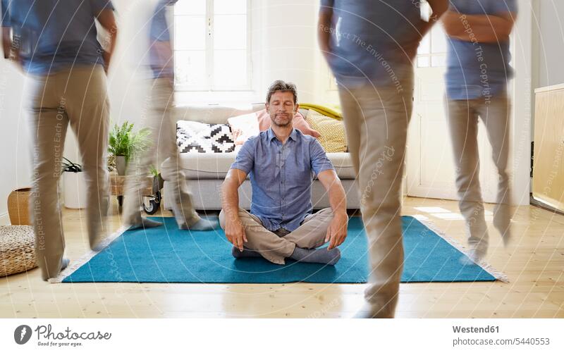 Am Boden sitzender, meditierender Mann sitzt Yoga Böden Boeden Männer männlich Entspannung entspannt Entspannen relaxen entspannen Zuhause zu Hause daheim
